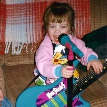 Ana Playing with Toy Guitars and Microphones at an Early Age.